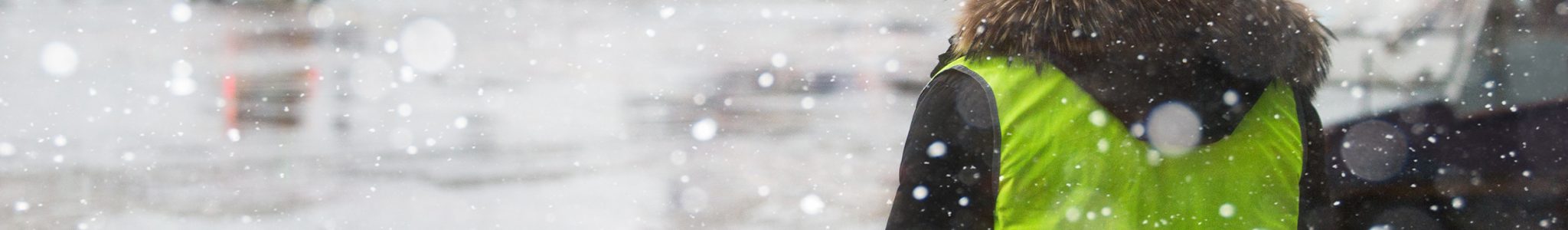 Airport manager standing under snowfall Travailleurs isolés hiver
