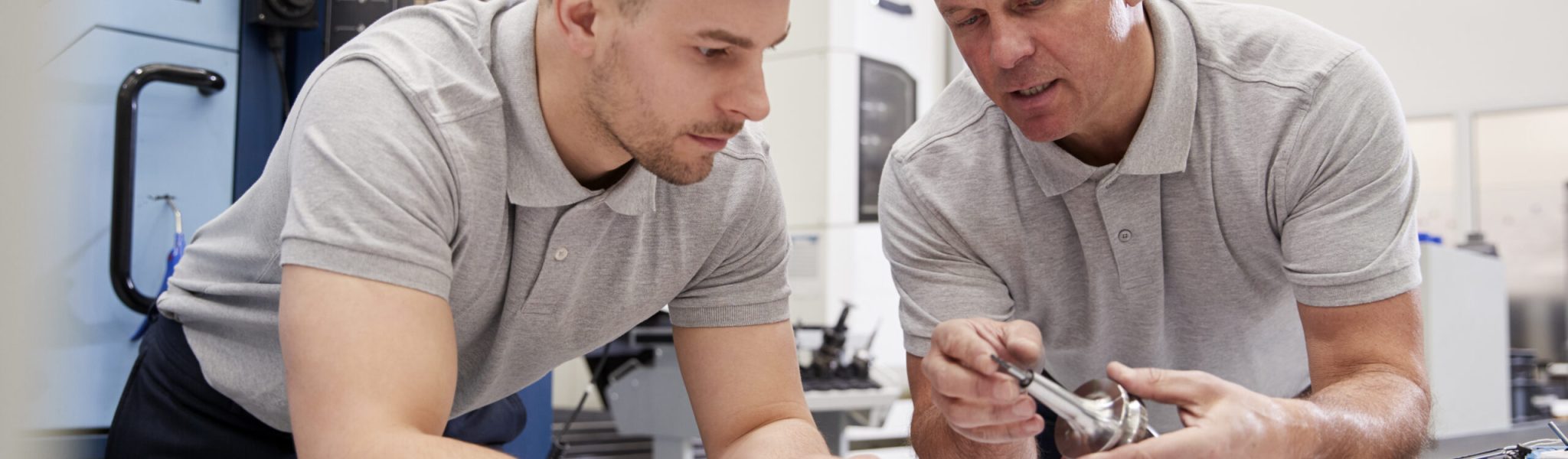Engineer Showing Apprentice How To Measure CAD Drawings Enjeux du travail isolé dans l'entreprise